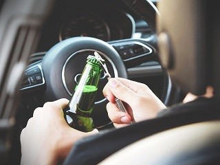 kierowca trzymający butelkę piwa